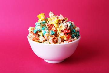 Fototapeta na wymiar Sweet colourful popcorn on pink background
