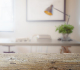 wooden table top with blur of modern working table with book and