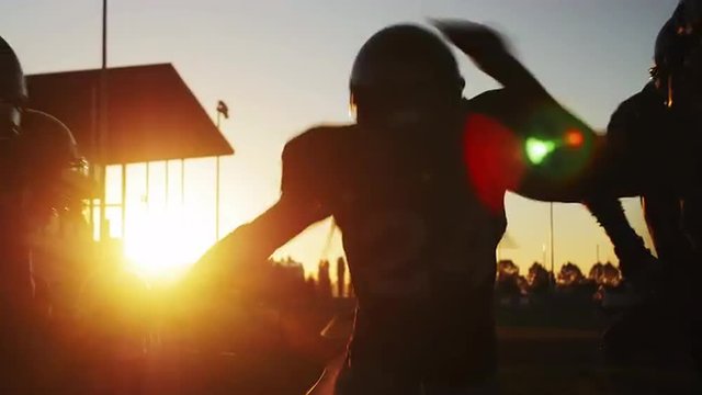 Football players get pumped and run onto the field
