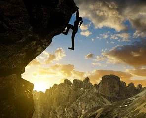 Poster Silhoutte of girl climbing on rock at sunset in Sexten Dolomites, South Tyrol, Italy © vencav