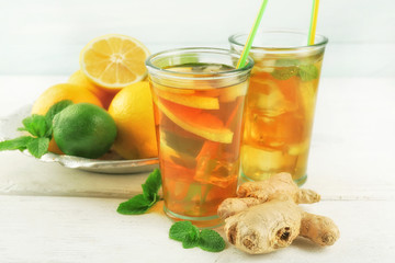 Iced tea with lemon on light wooden background
