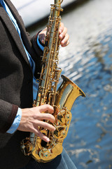 Fototapeta premium Saxophonist plays jazz outdoors, close up