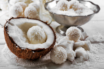 Homemade Candies in coconut flakes and fresh coconut on light background