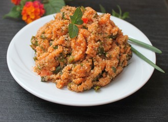 Couscous salad with tomatoes, greens and lemon juice and olive oil, Turkish national dish kysyr