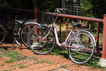 Bicycle Leaning Against Fence On The Orange Brick Tile  Floor