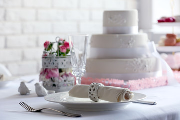 Layered wedding cake on decorated table in restaurant