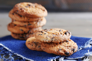 Cookies with chocolate crumbs on wooden table against blurred background, close up