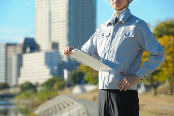 青空の下で働く作業服の男性