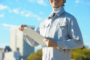 青空の下で働く作業服の男性