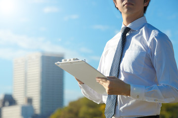 青空の下で働く若いビジネスマン
