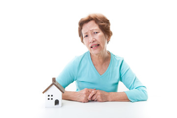 高齢者の日本人女性と住宅模型