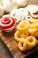 Chips rings with sauce and onion on cutting board