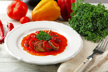 Ratatouille on plate, on table background