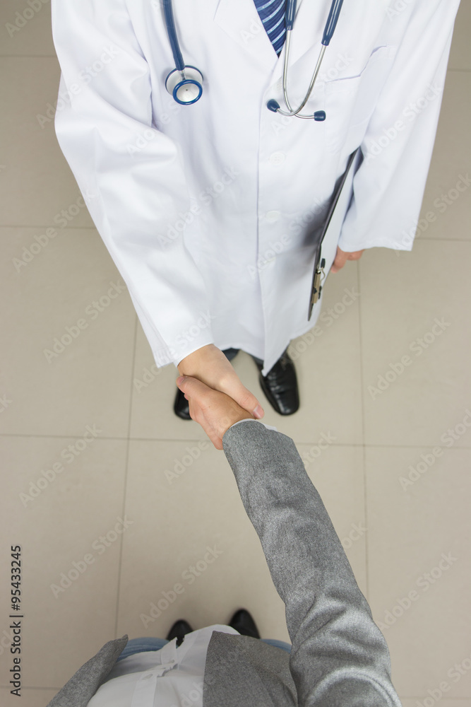 Wall mural Doctor and businessman shaking hands