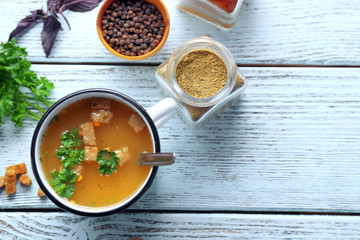 Mug of soup on blue wooden background