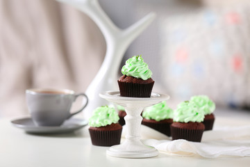 Beautiful chocolate cupcakes and cup of tea,  on table