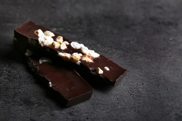 Black chocolate pieces and nuts on dark gray background
