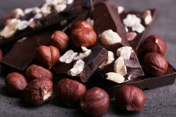 Black chocolate pieces and nuts on dark gray background