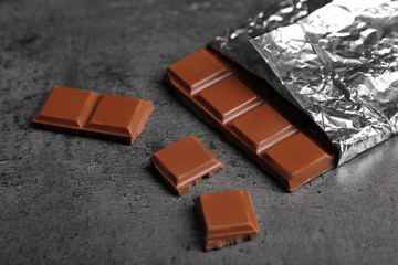 Chocolate bar in foil  on gray background