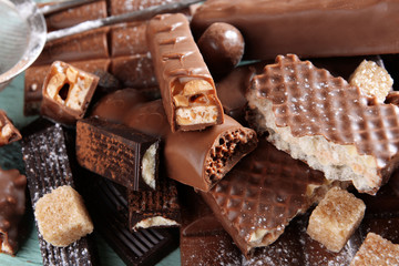 Chocolate sweets with powder on wooden background
