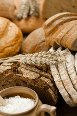 Assortment of baked bread on wooden table background