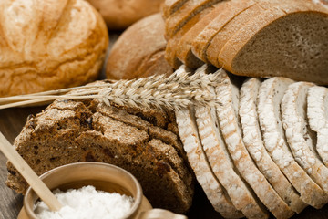 Assortment of baked bread on wooden table background