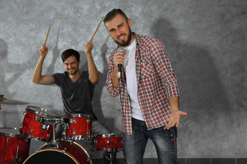 Musicians playing musical instruments and singing songs in a studio