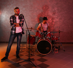 Musicians playing musical instruments and singing songs in a studio