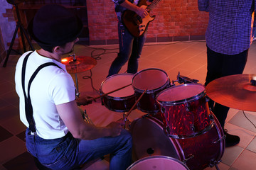 Fototapeta na wymiar Musicians playing musical instruments on brick wall background