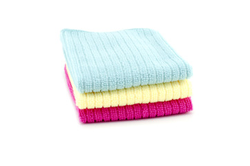 Pile of neatly folded colorful cotton towels in blue,yellow and red color isolated on white background