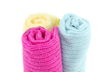 rolled up yellow, blue and red bathroom towels isolated on white background