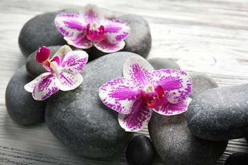 Fototapeta na wymiar Spa stones and orchids on wooden background