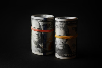 Dollars roll on black background