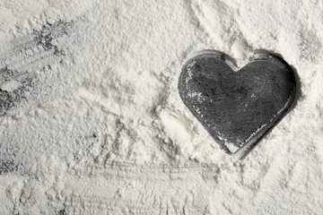 Heart of flour on gray background