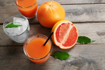 Citrus juice with ice and fresh fruits on wooden background