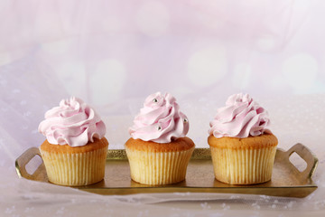 Tasty cupcakes on light background
