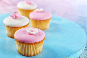 Tasty cupcakes on color wooden background