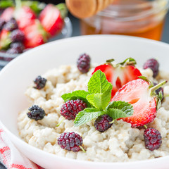 Breakfast - oatmeal with honey and berries, blue bowl