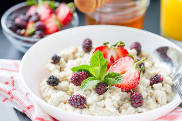 Breakfast - oatmeal with honey and berries, blue bowl