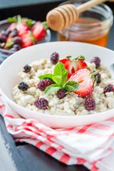 Breakfast - oatmeal with honey and berries, blue bowl
