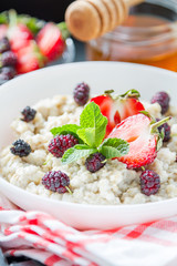 Breakfast - oatmeal with honey and berries, blue bowl