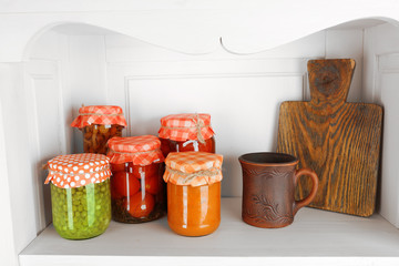 Jars with pickled vegetables on shelf