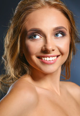 Obraz premium Beautiful woman with curly long hair on dark background