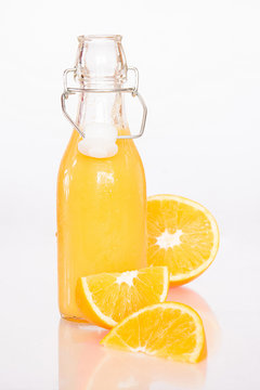 Orangensaft mit halbierter Orange und Orangenvierteln