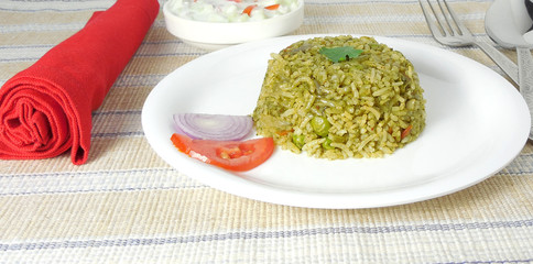 Spinach rice or palak rice, a popular Indian vegetarian dish made from spinach puree, pea and other ingredients.