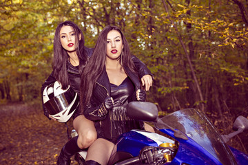 Fototapeta na wymiar two beautiful women passionate about motorcycles, posing in natu