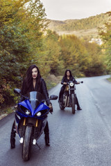 Fototapeta na wymiar two beautiful women passionate about motorcycles, posing in natu