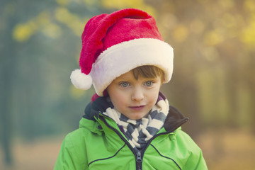 boy with Santa hat in park