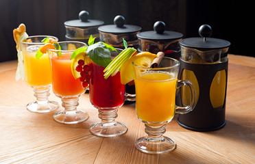 four teapots and glasses with different colors fruit tastes of tea