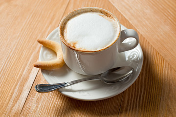 cookie and cup of coffee on wooden table